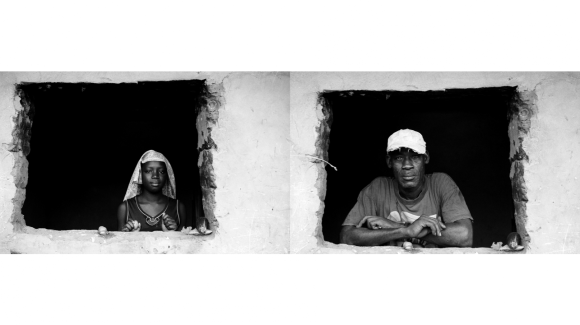Retratos de una joven y un señor de raza negra asomados a la ventana de su casa.
