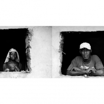 Retratos de una joven y un señor de raza negra asomados a la ventana de su casa.
