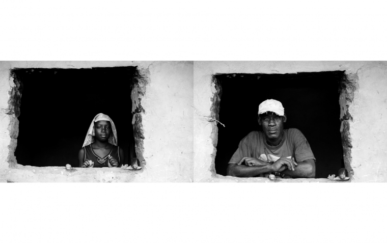 Retratos de una joven y un señor de raza negra asomados a la ventana de su casa.